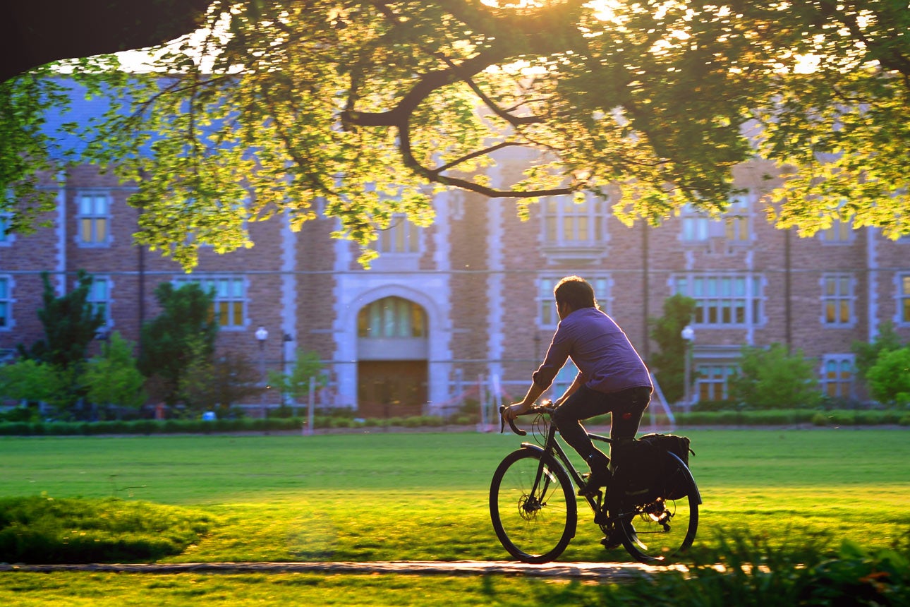 A student rides a bike on campus.